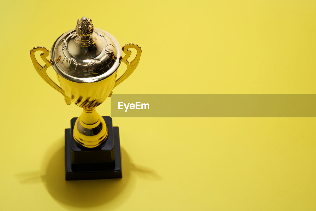 Close up of trophy on yellow background