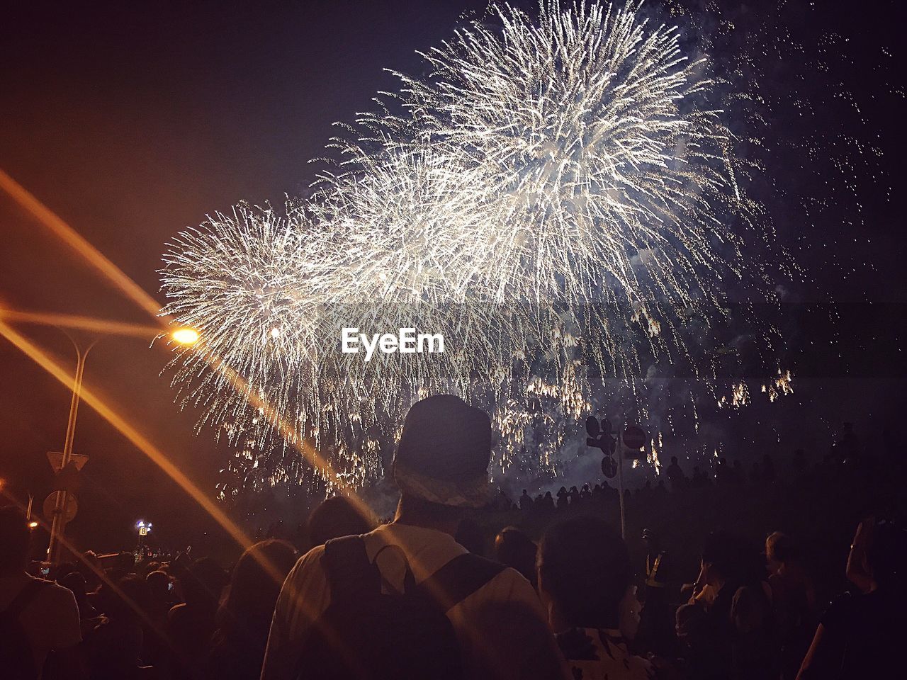 Low angle view of people looking at firework display