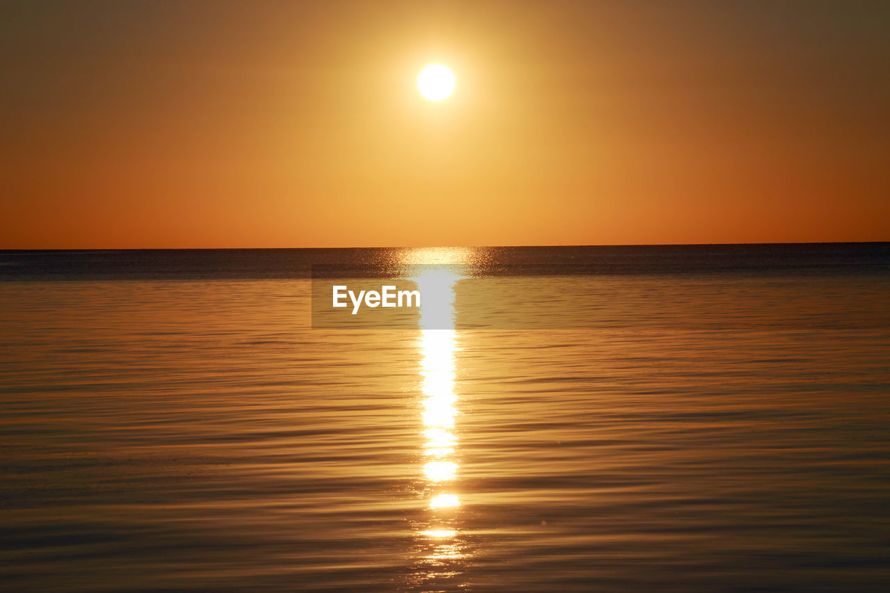 water, sky, sea, sunset, beauty in nature, scenics - nature, horizon over water, tranquility, reflection, sun, horizon, tranquil scene, nature, sunlight, idyllic, orange color, afterglow, no people, seascape, rippled, outdoors, dramatic sky, astronomical object, land, beach, urban skyline, dawn, ocean, waterfront, non-urban scene, sunbeam, holiday, vacation, evening, trip, silhouette, light, summer, travel destinations, travel