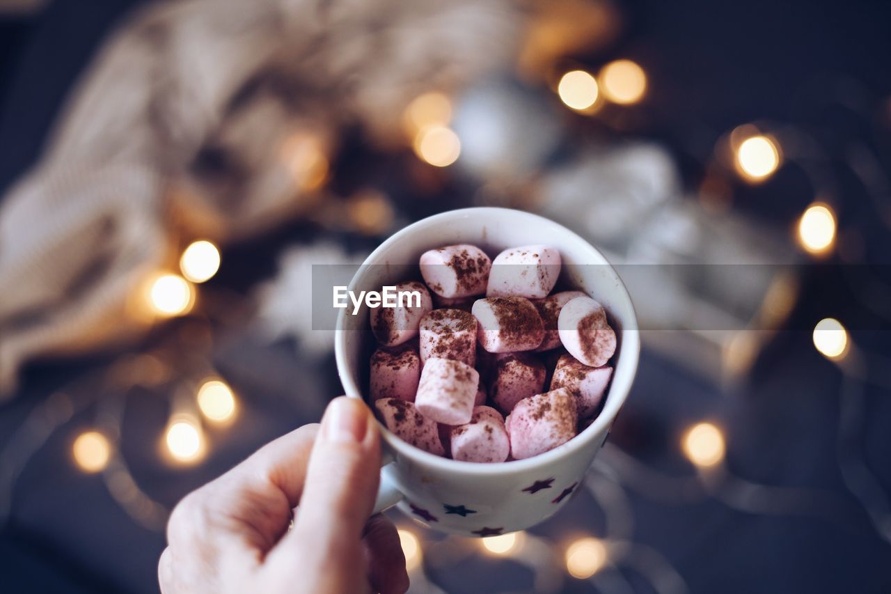 Cropped hand holding marshmallow cup