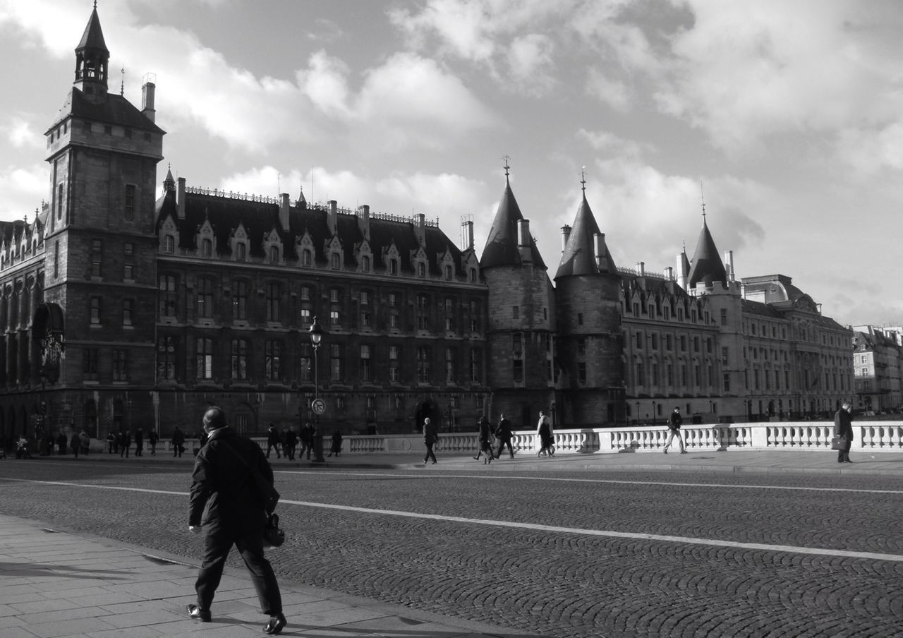 REAR VIEW OF MAN WALKING IN CITY