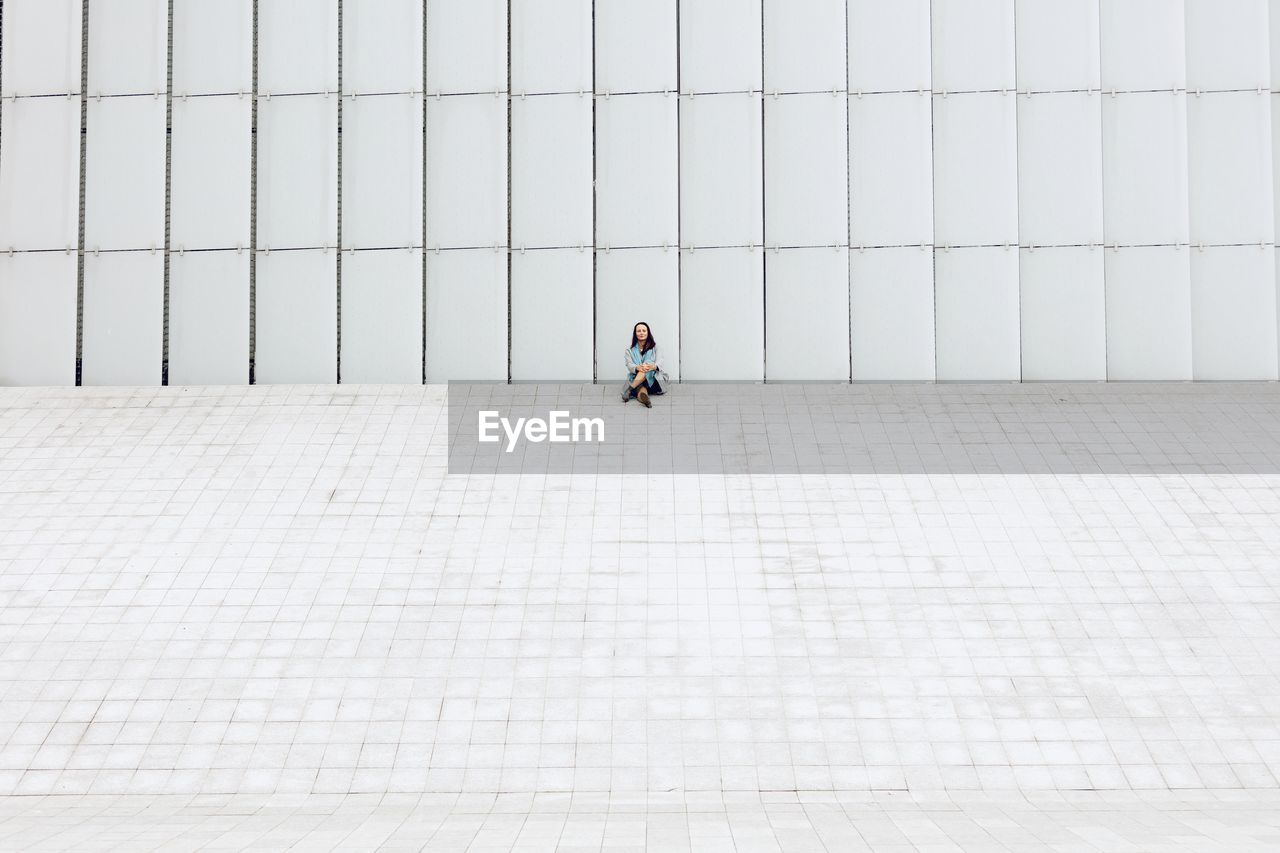 Rear view of woman walking against building in city