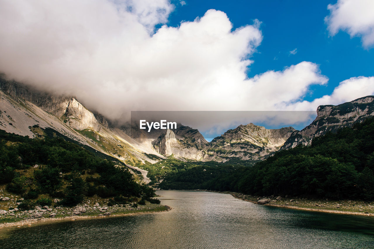 Scenic view of river amidst mountains against sky