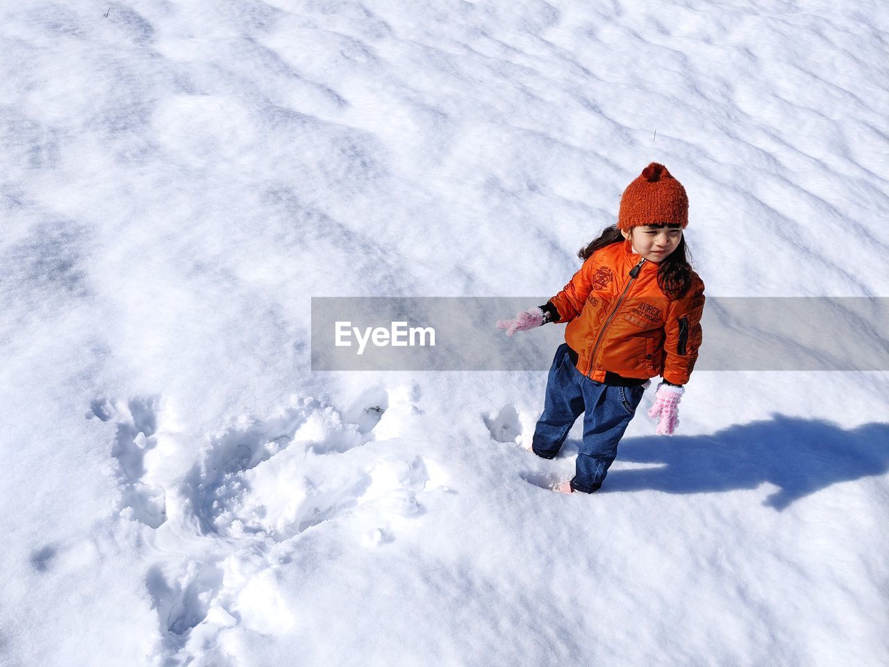 High angle view of girl standing on snow covered land