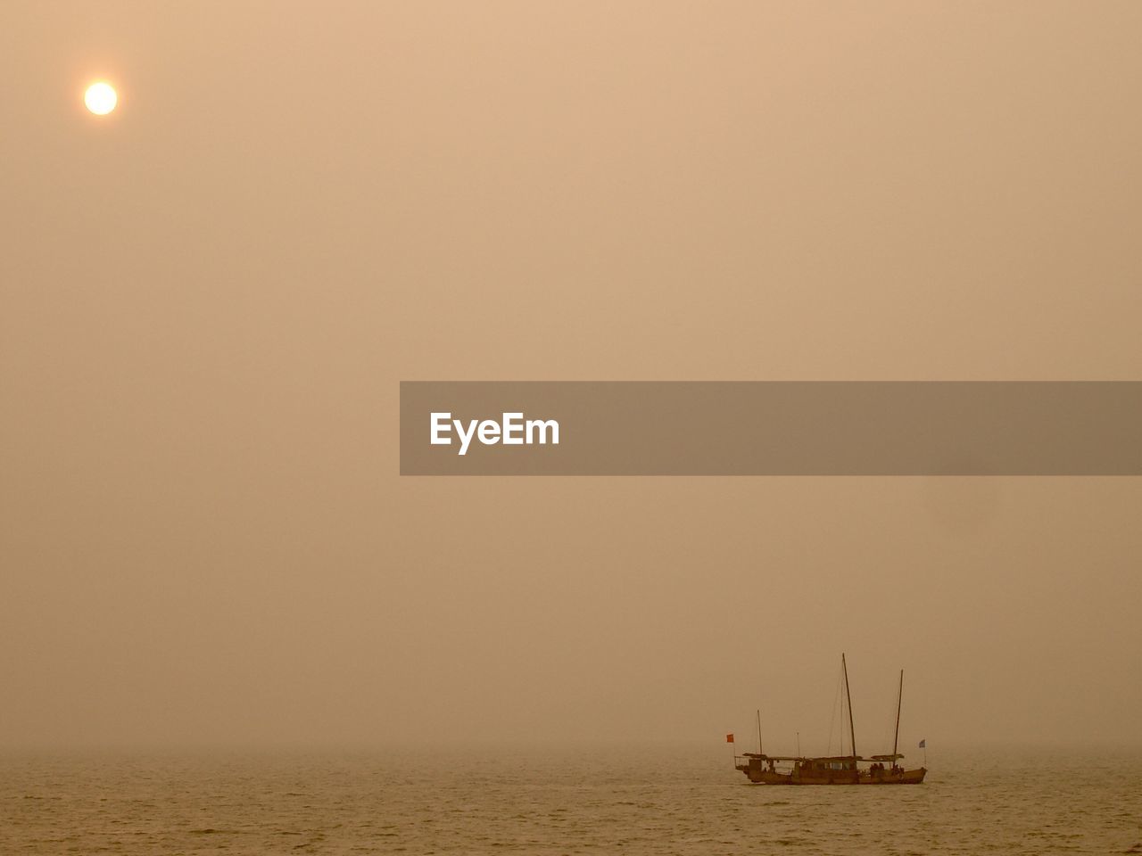 Sailboat sailing on sea against sky during sunset