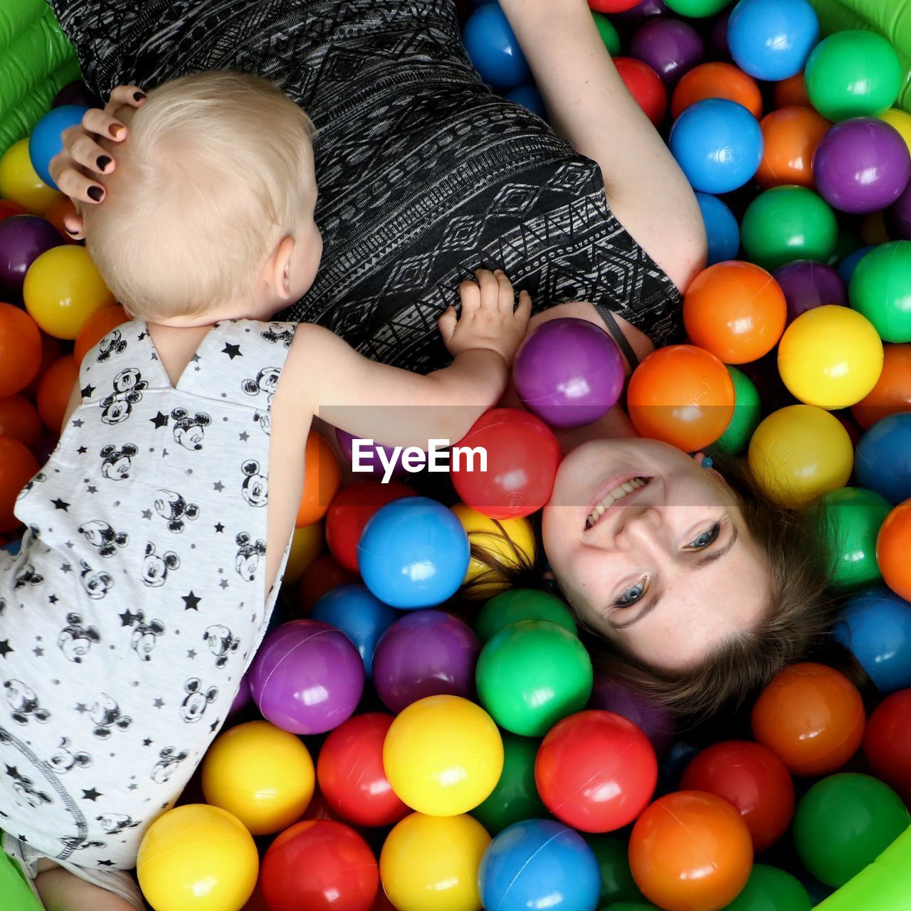 High angle view of mother with son playing in ball pool