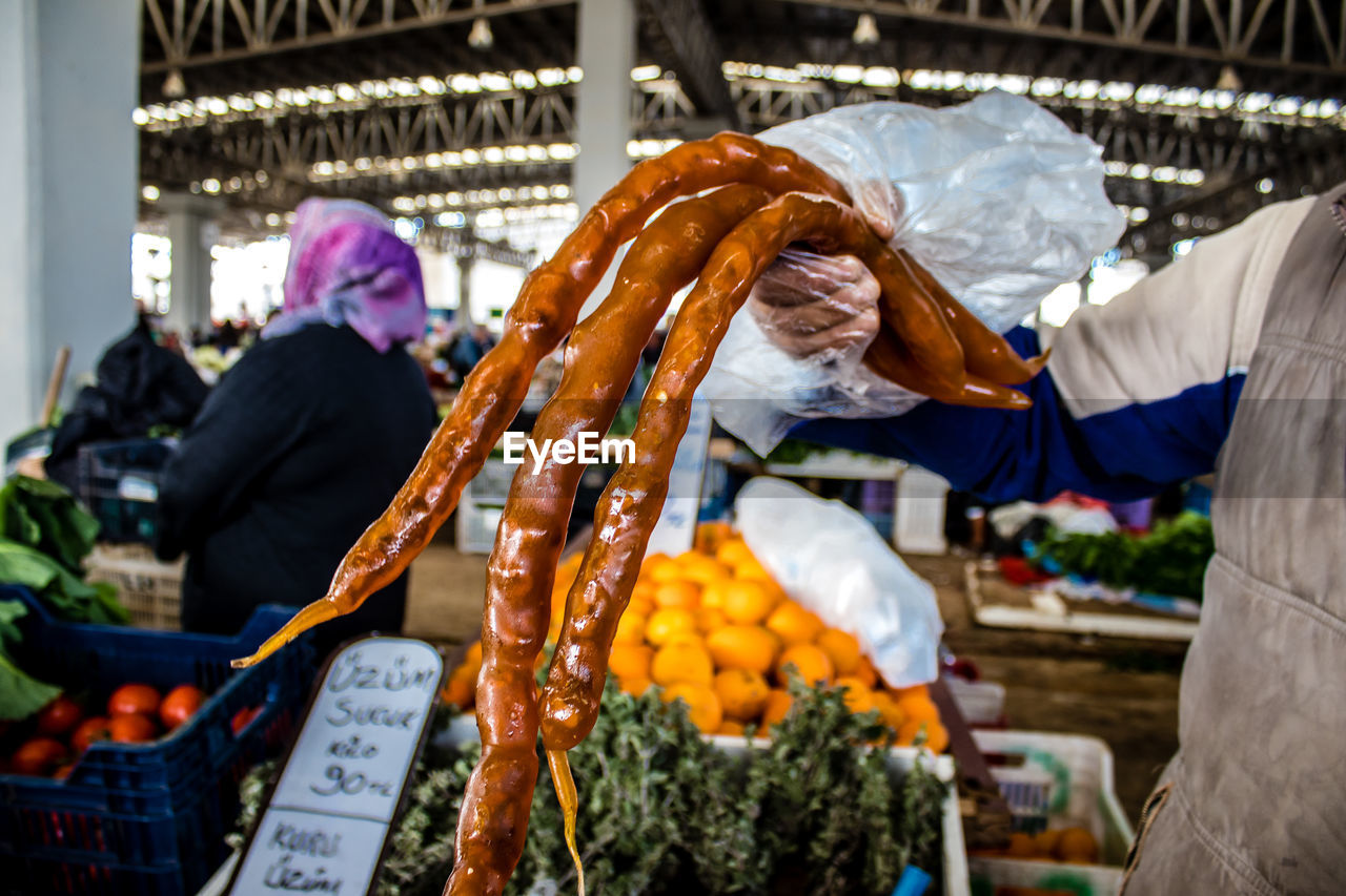 rear view of man holding fruits at market stall