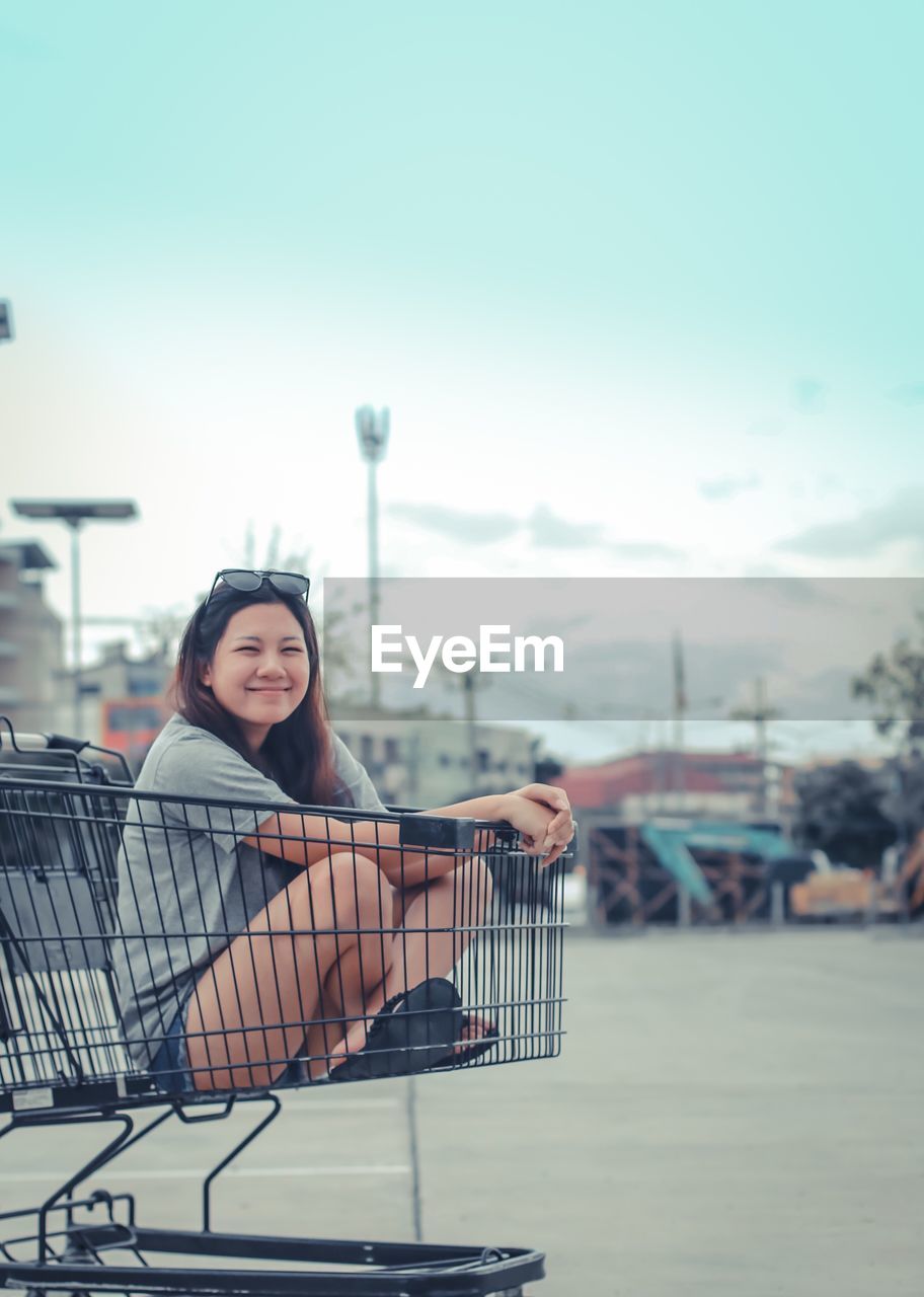 Portrait of smiling young woman sitting outdoors