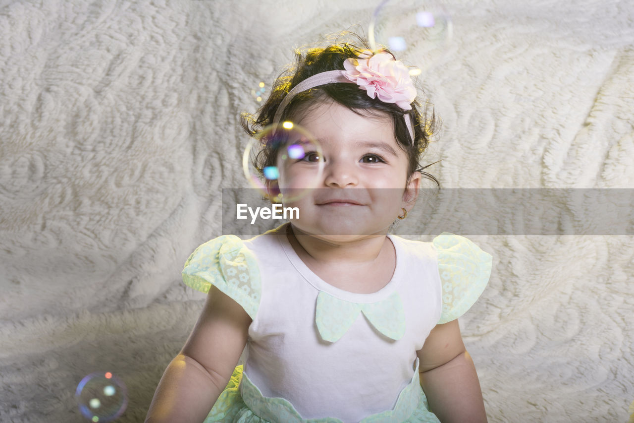 Portrait of cute baby girl smiling sitting at home