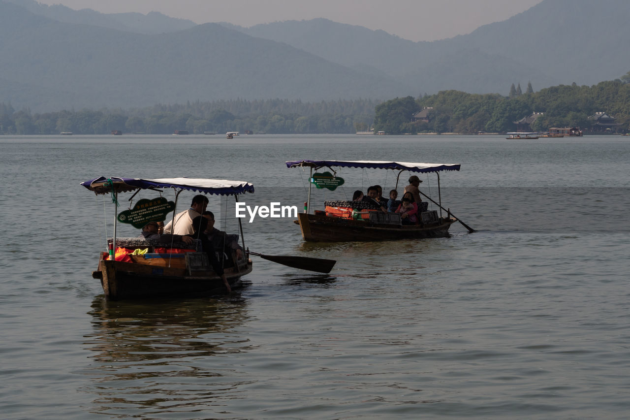 PEOPLE IN BOAT SAILING ON SEA