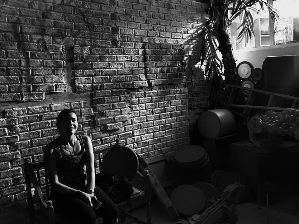 black, black and white, monochrome, darkness, monochrome photography, brick wall, one person, brick, wall - building feature, sitting, adult, wall, white, lifestyles, indoors, women, seat, chair, architecture, young adult, leisure activity, casual clothing, built structure, person