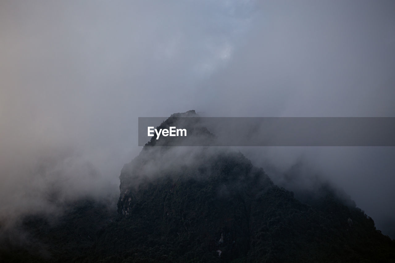 LOW ANGLE VIEW OF MOUNTAIN AGAINST CLOUDY SKY