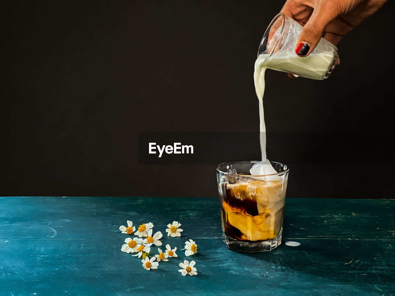 MIDSECTION OF PERSON POURING DRINK IN GLASS