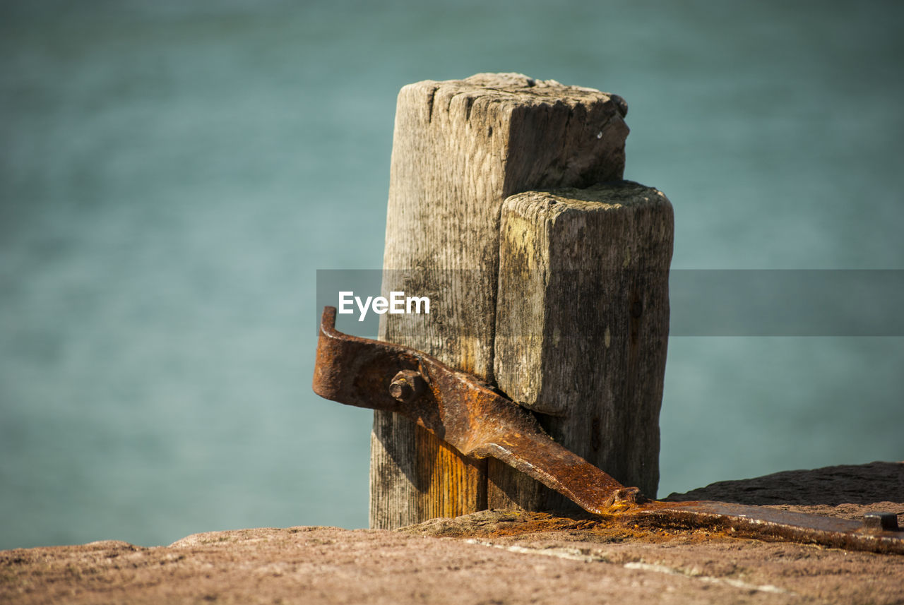 CLOSE-UP OF RUSTY PIPE AGAINST SEA