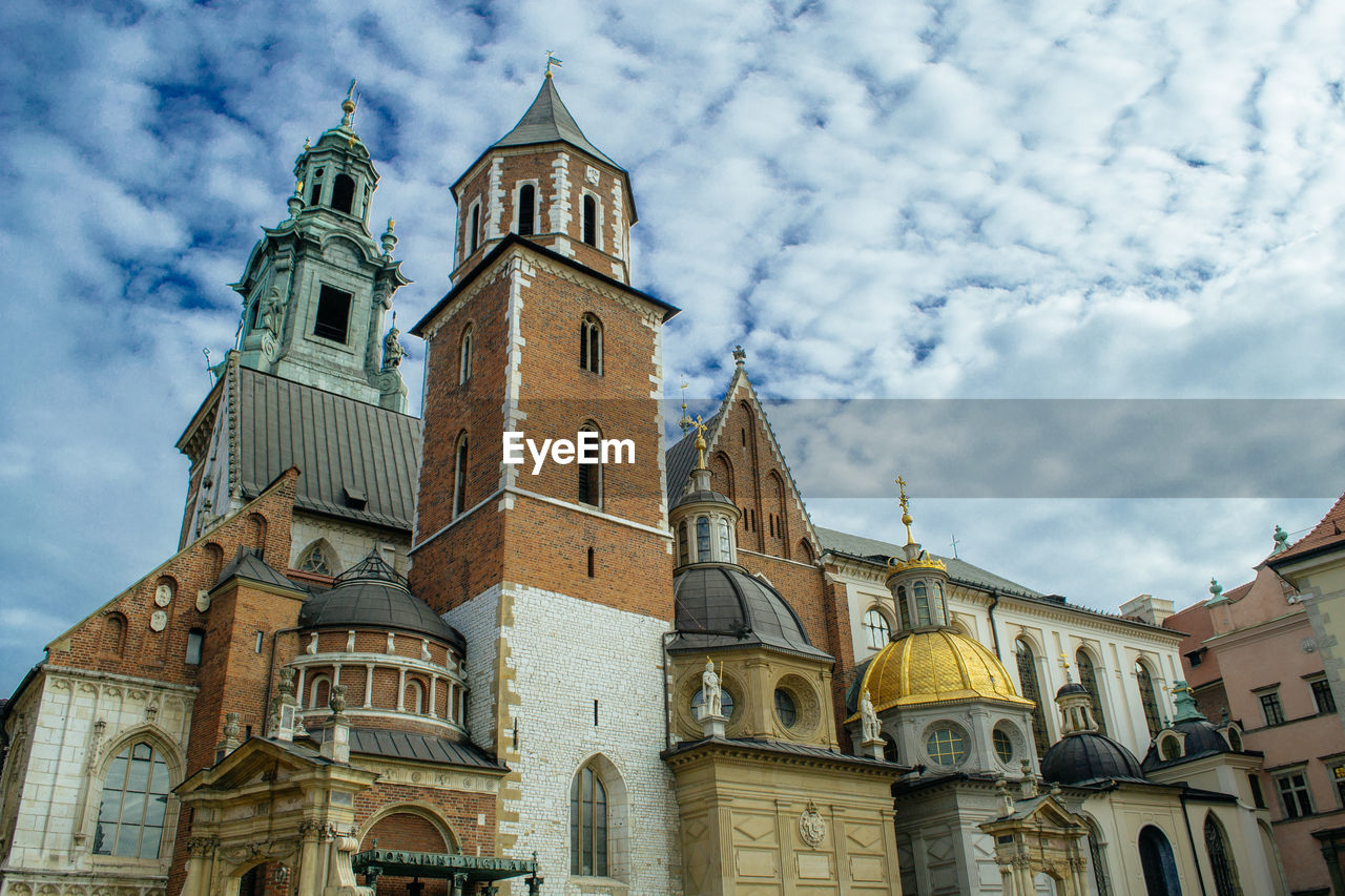 Low angle view of wawel cathedral against cloudy sky