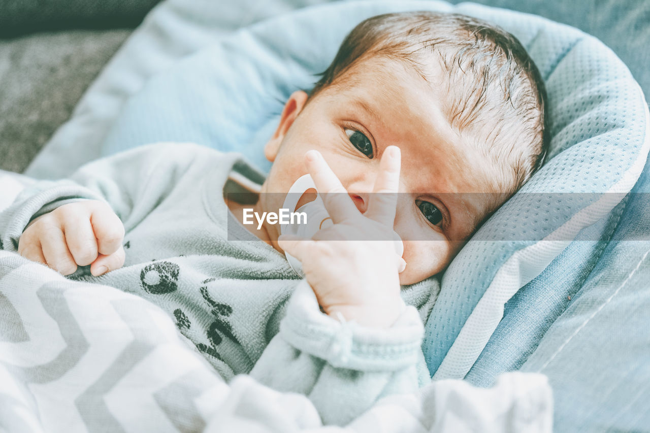 Portrait of baby girl lying on bed