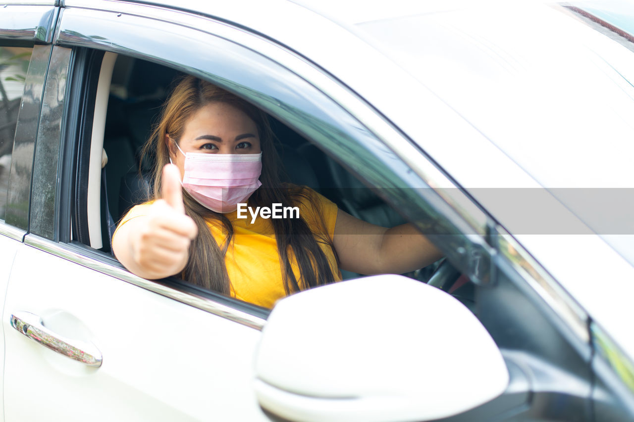 PORTRAIT OF A YOUNG WOMAN WITH CAR IN BUS