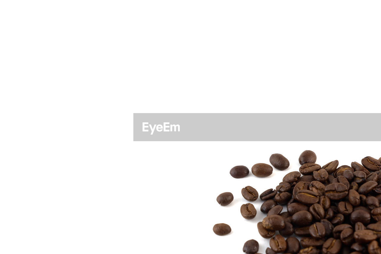 CLOSE-UP OF COFFEE BEANS OVER WHITE BACKGROUND