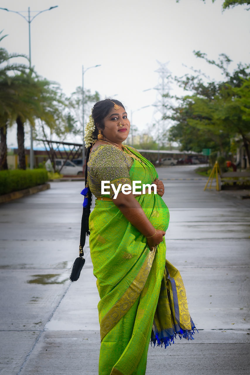 Portrait of young woman walking on street