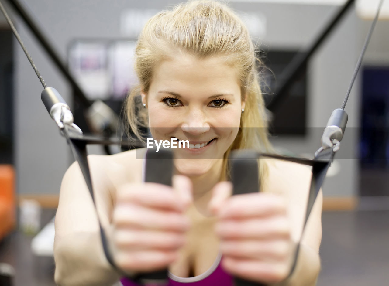 Portrait of young woman exercising in gym