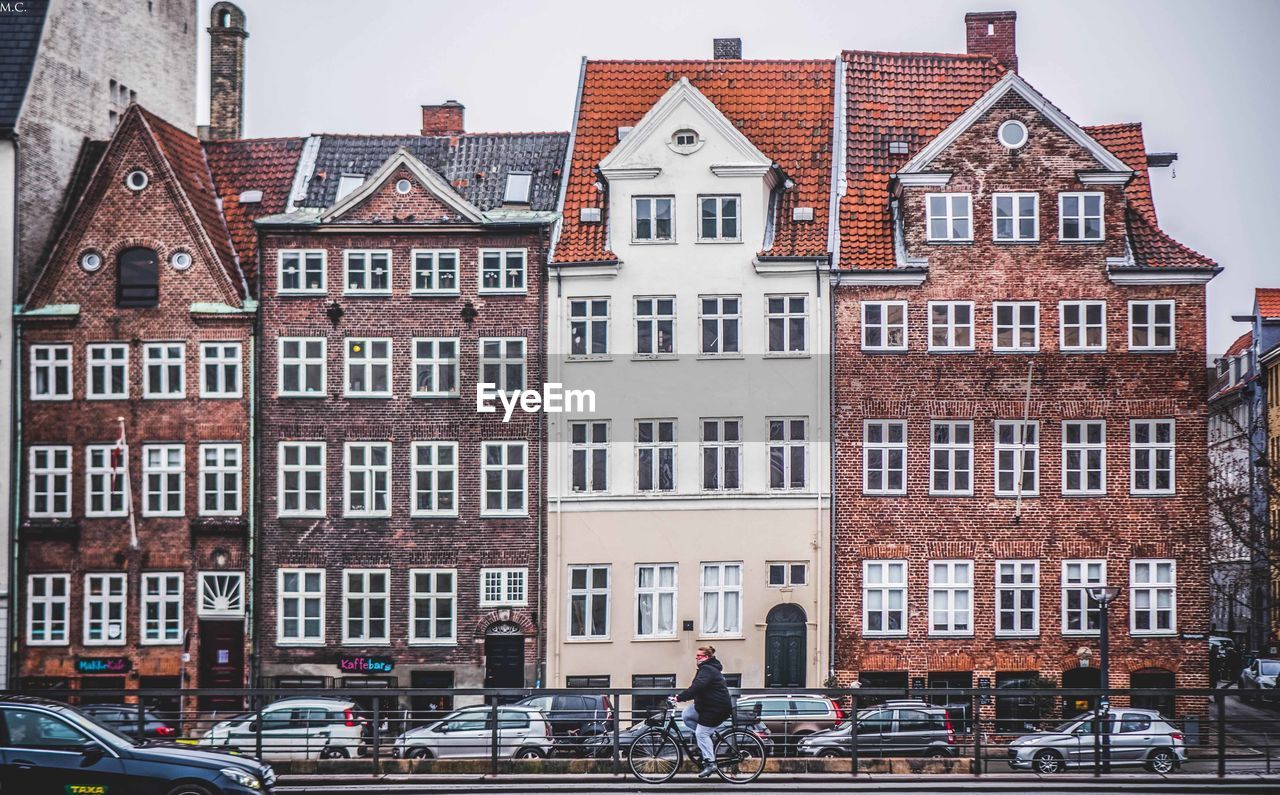 BUILDINGS BY ROAD AGAINST SKY