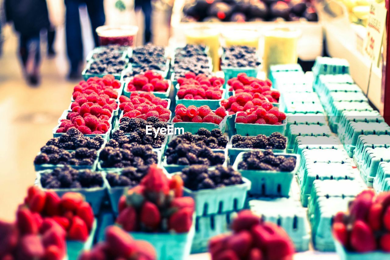 Cardboard boxes of blueberries and raspberries for sale