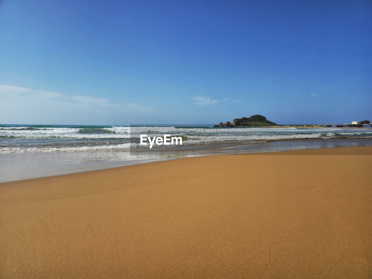 land, sea, beach, water, sky, sand, body of water, scenics - nature, wave, beauty in nature, nature, horizon, ocean, water's edge, motion, tranquility, coastline, water sports, horizon over water, coast, surfing, travel destinations, sports, shore, tranquil scene, environment, holiday, wind wave, cloud, trip, blue, vacation, landscape, travel, outdoors, singing sand, seascape, day, copy space, tourism, clear sky, summer, idyllic, sunny