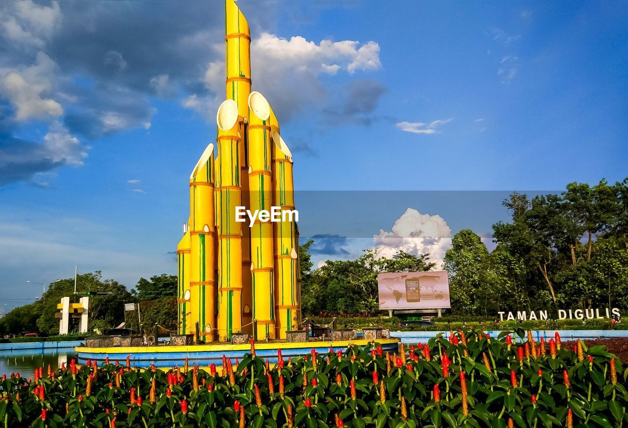 YELLOW FLOWERING PLANTS AGAINST CLOUDY SKY