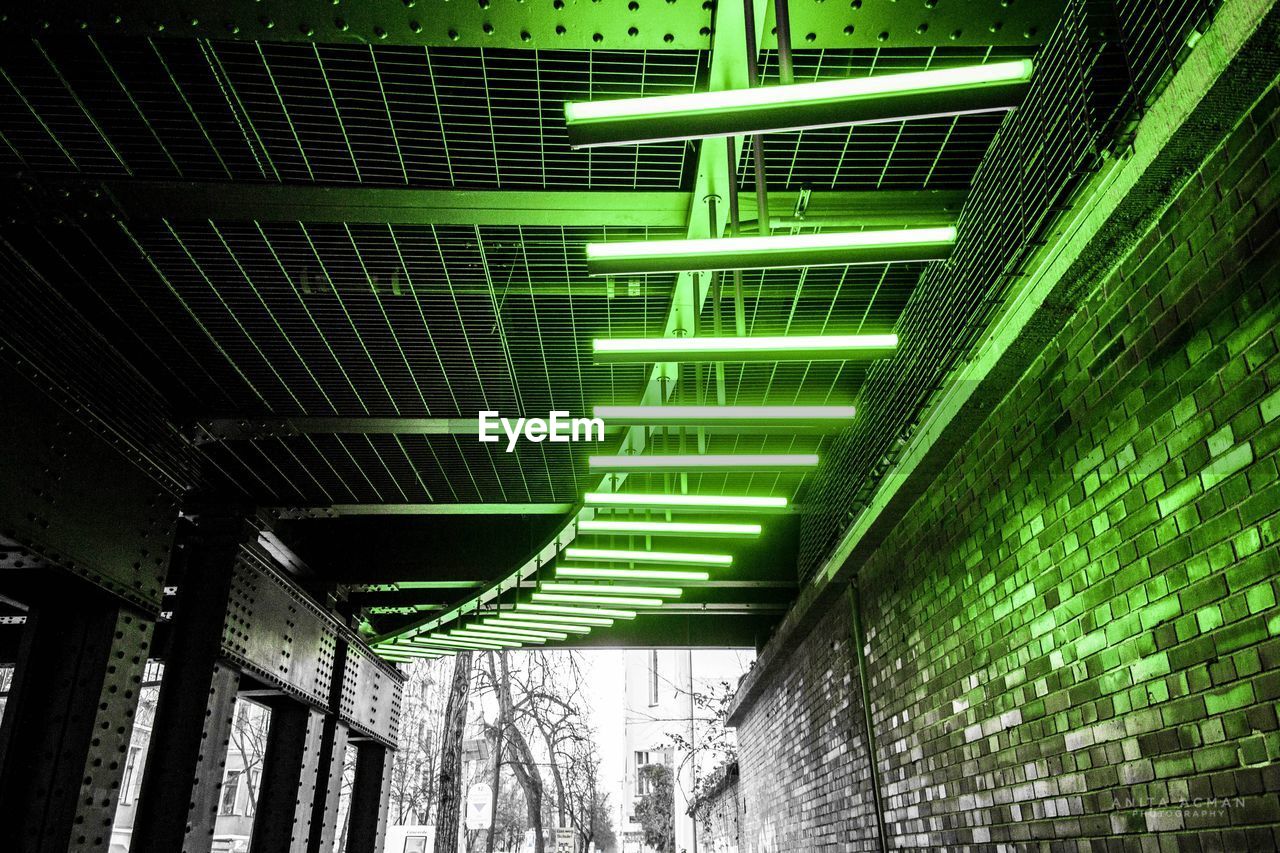 LOW ANGLE VIEW OF ILLUMINATED UNDERGROUND WALKWAY