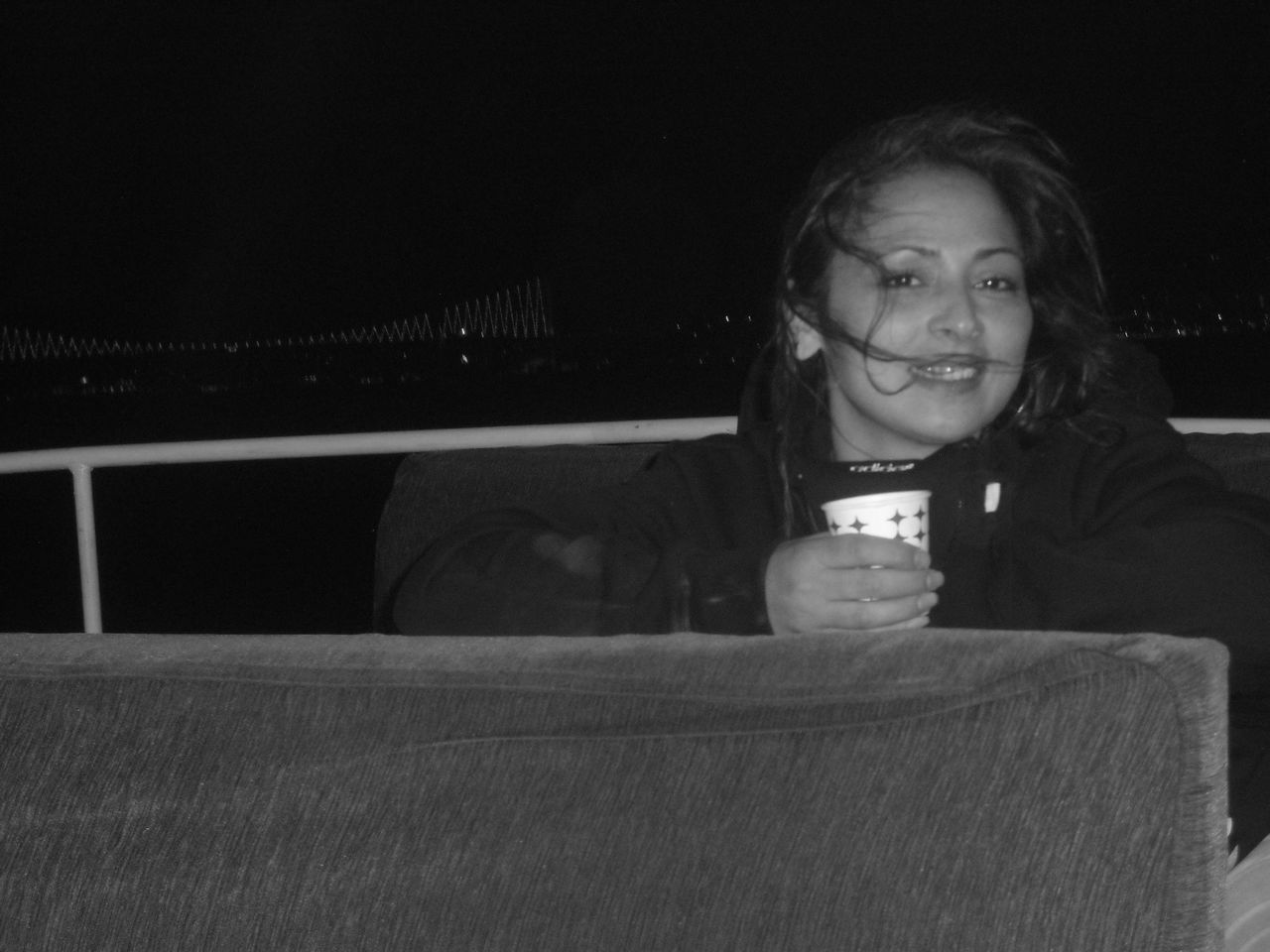 Portrait of happy woman sitting outdoors at night