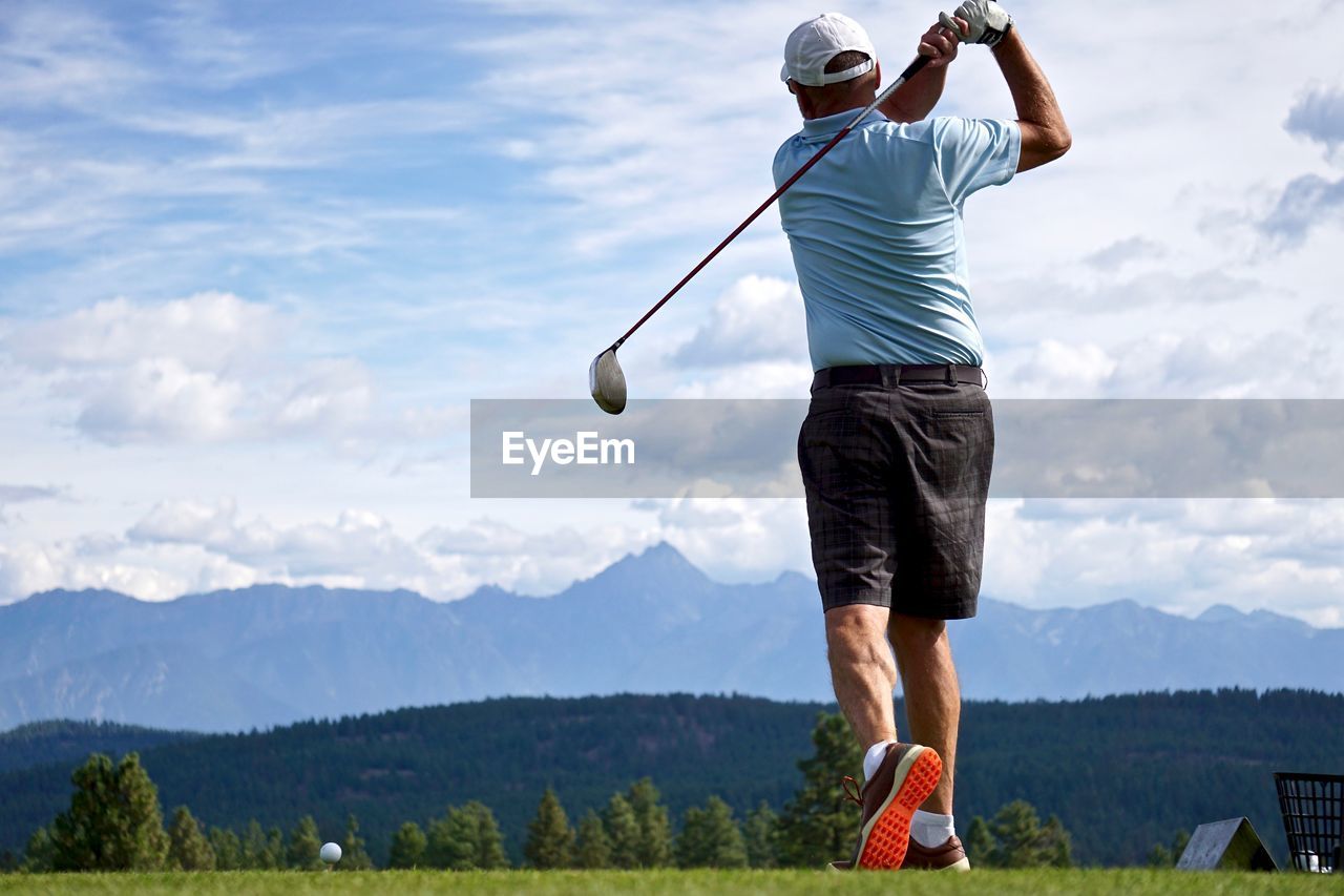 Rear view of man standing on golf course