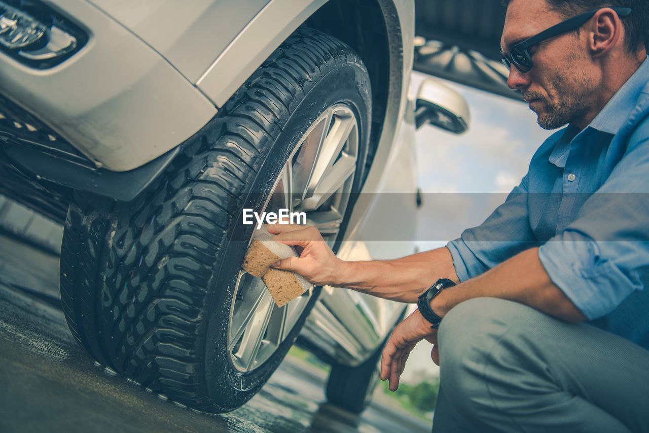 Man cleaning car tire