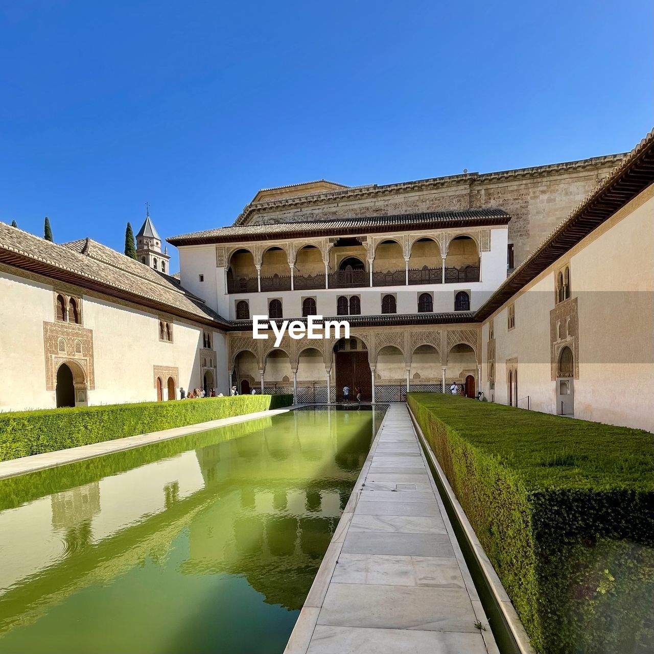 architecture, built structure, estate, building exterior, water, nature, sky, travel destinations, building, château, palace, clear sky, history, blue, the past, travel, tourism, city, reflection, mansion, sunny, no people, waterway, outdoors, plant, day, reflecting pool, residential district, lake, moat, house, grass, copy space