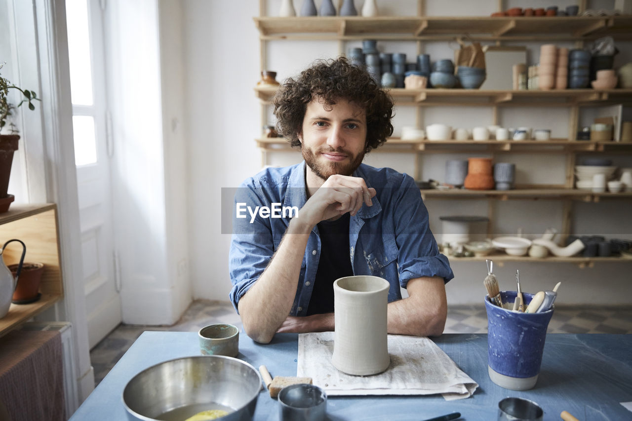 Portrait of mid adult man sitting in pottery class