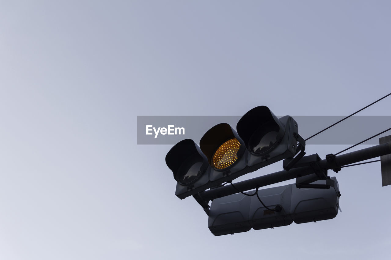Low angle view of road signal against clear sky