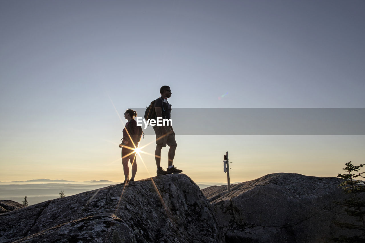 Young adult couple takes looks at view from summit, moxie bald, maine