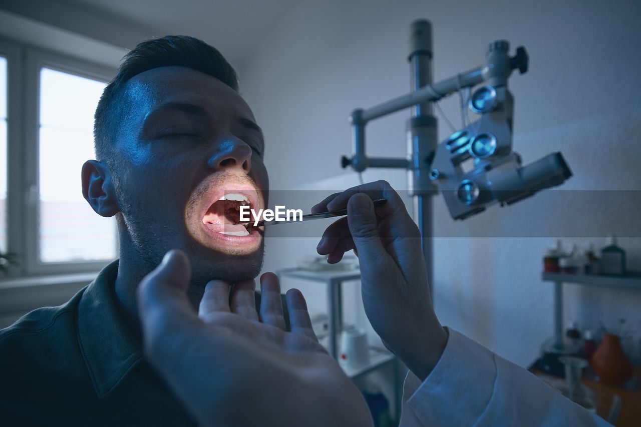 Cropped hand of doctor examining patients throat