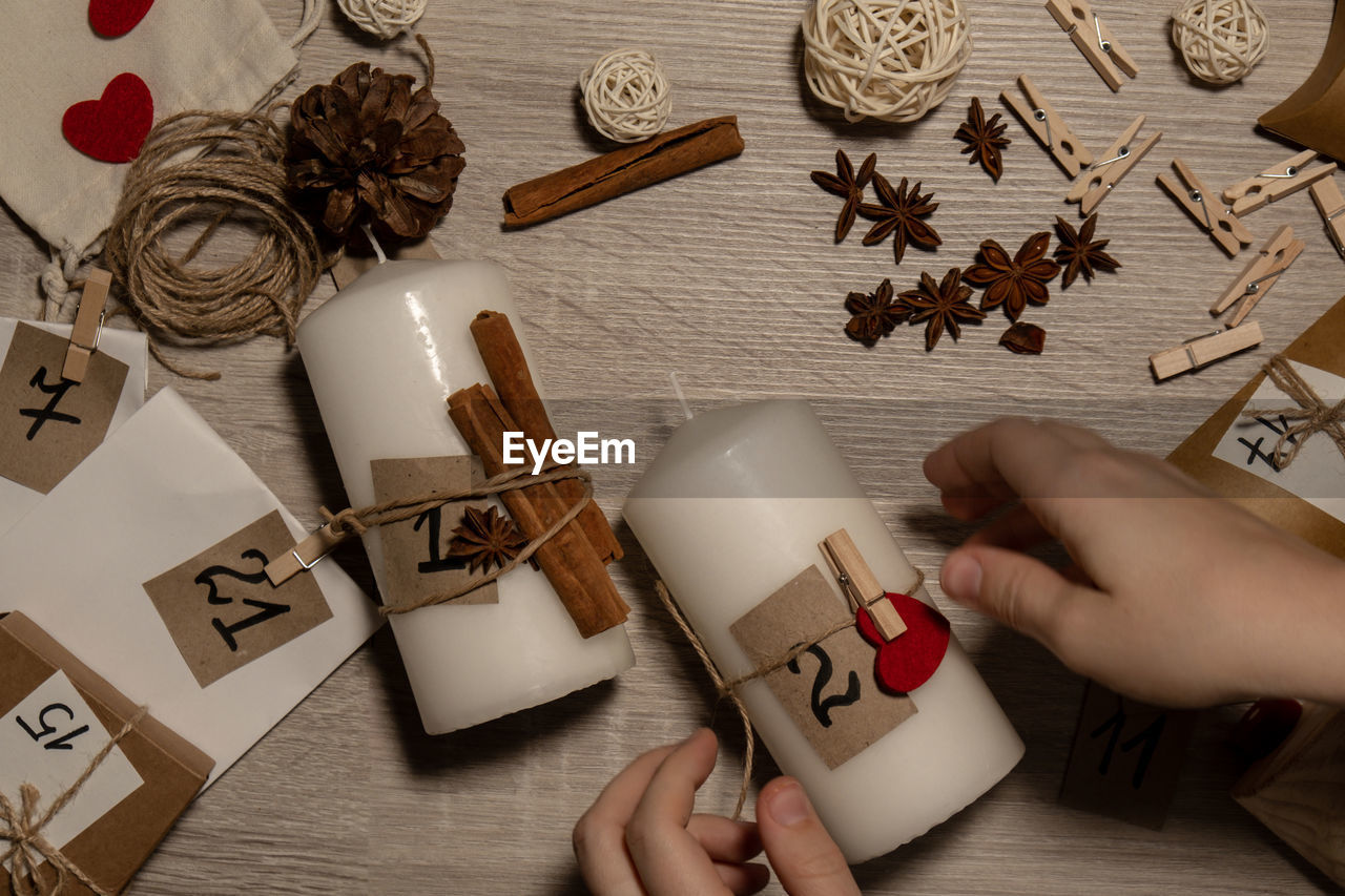 cropped hand of woman holding christmas presents on table