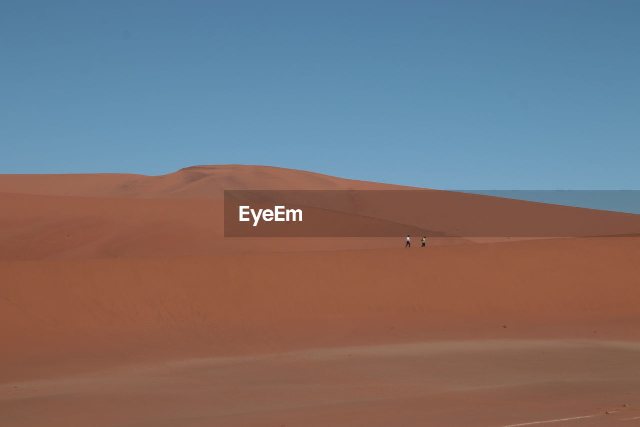 Scenic view of desert against clear blue sky