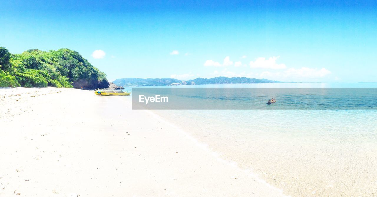 VIEW OF BEACH AGAINST BLUE SKY