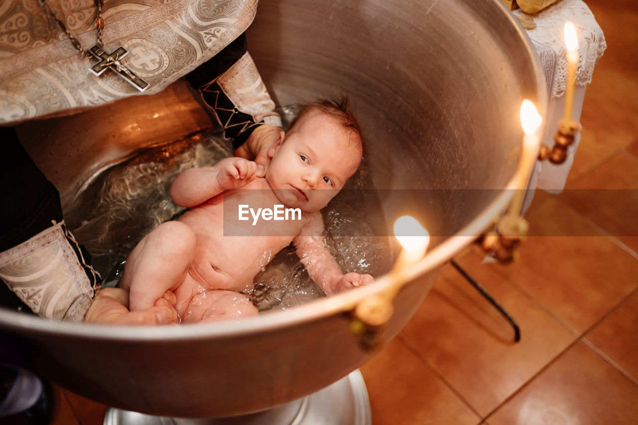 High angle view of person holding baby boy in bathroom