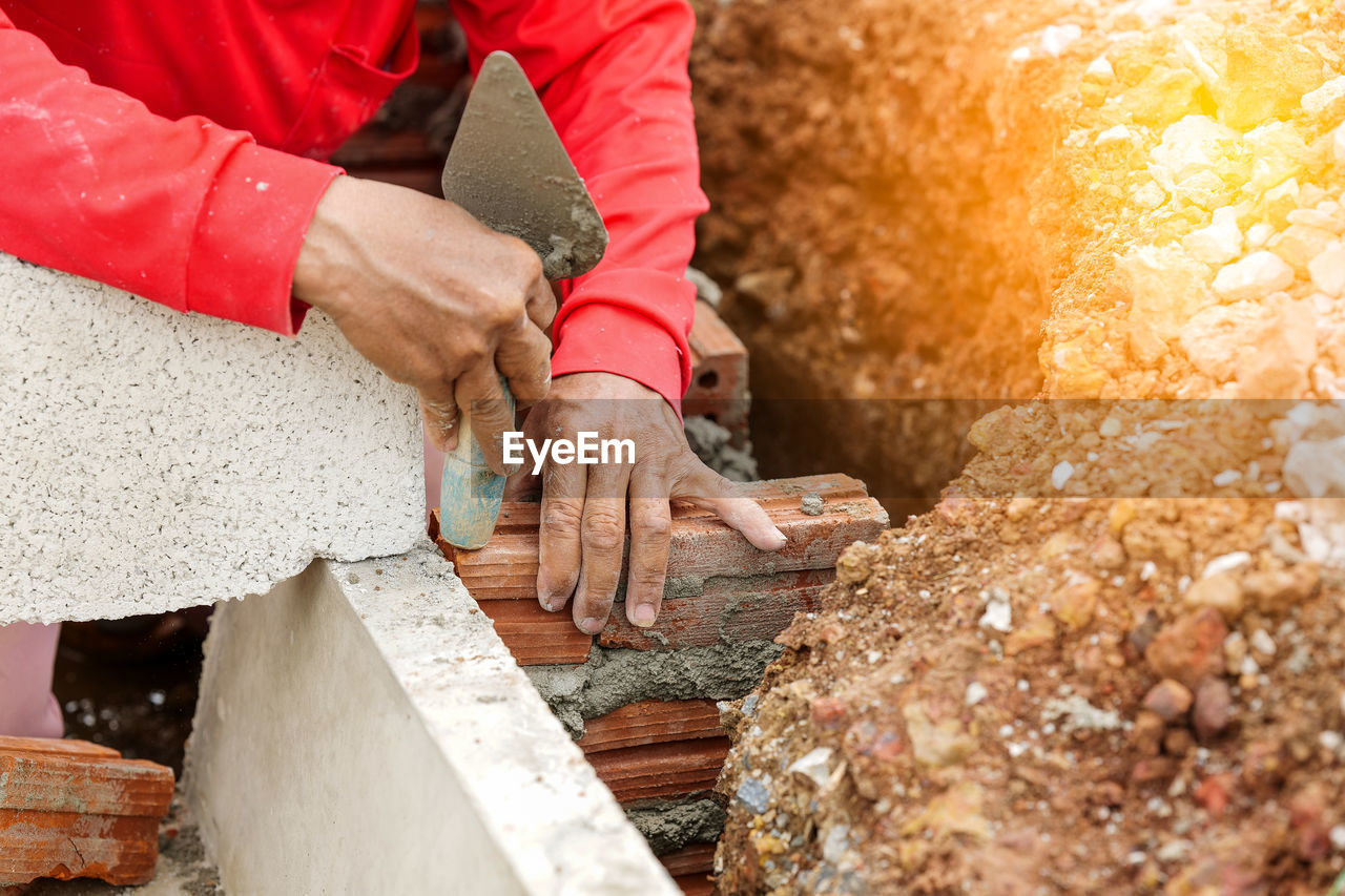 CLOSE-UP OF WORKER WORKING ON ROCK