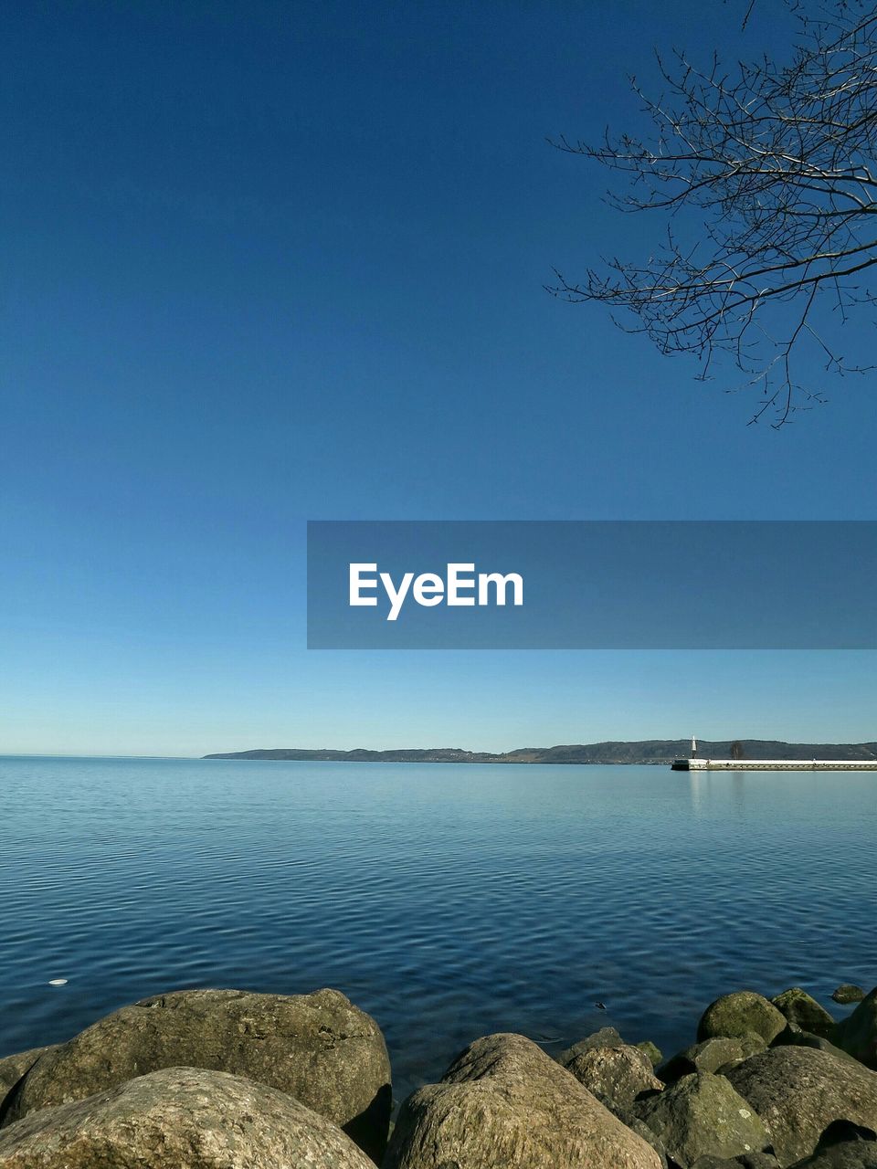 Scenic view of sea against clear blue sky