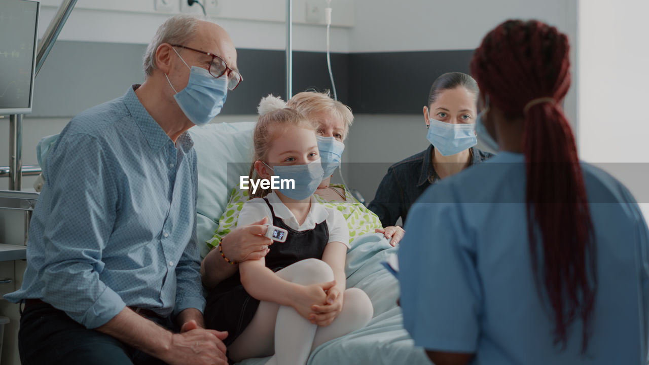 Nurse wearing mask talking with patients family