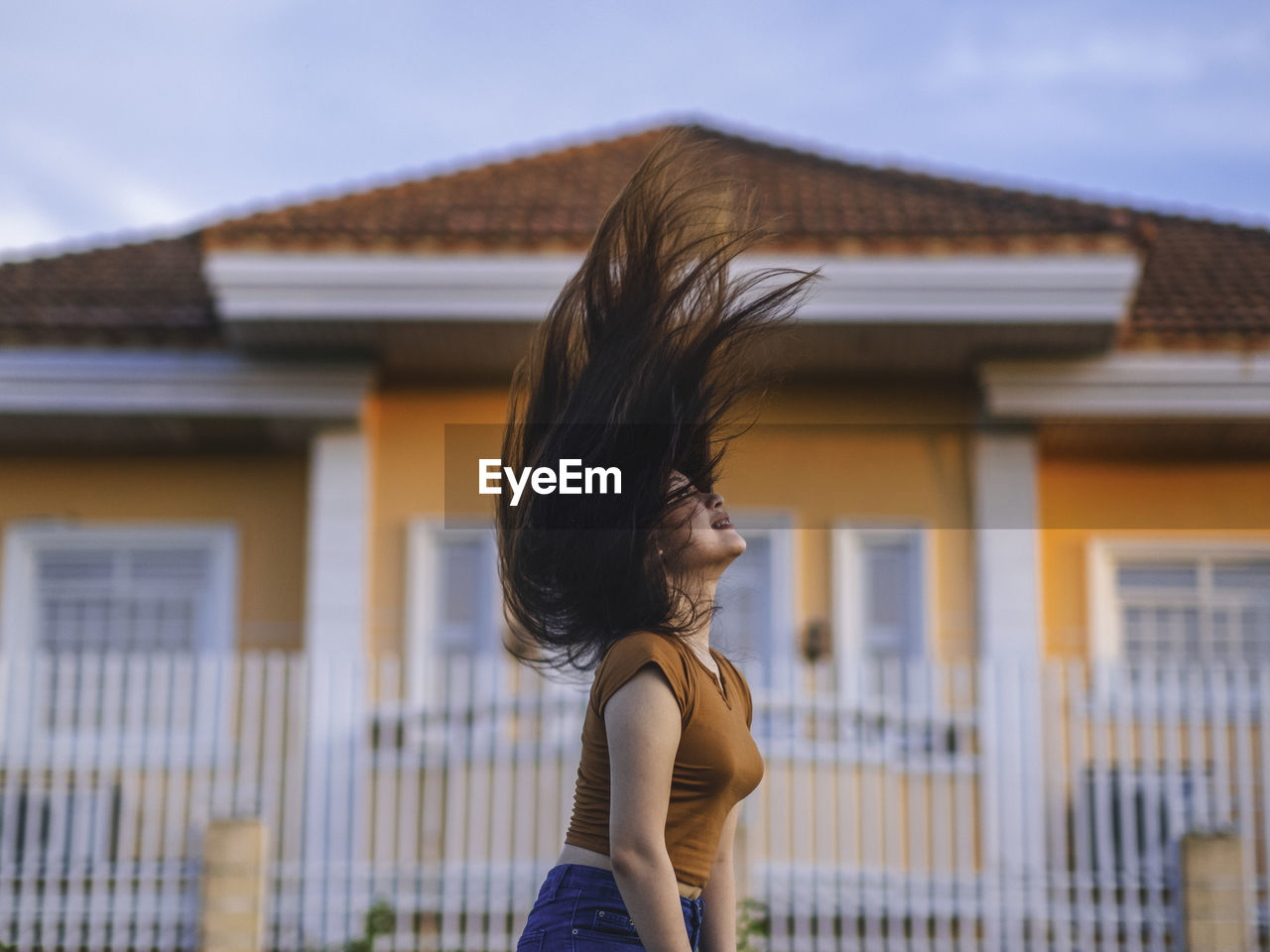 Side view of woman standing against building