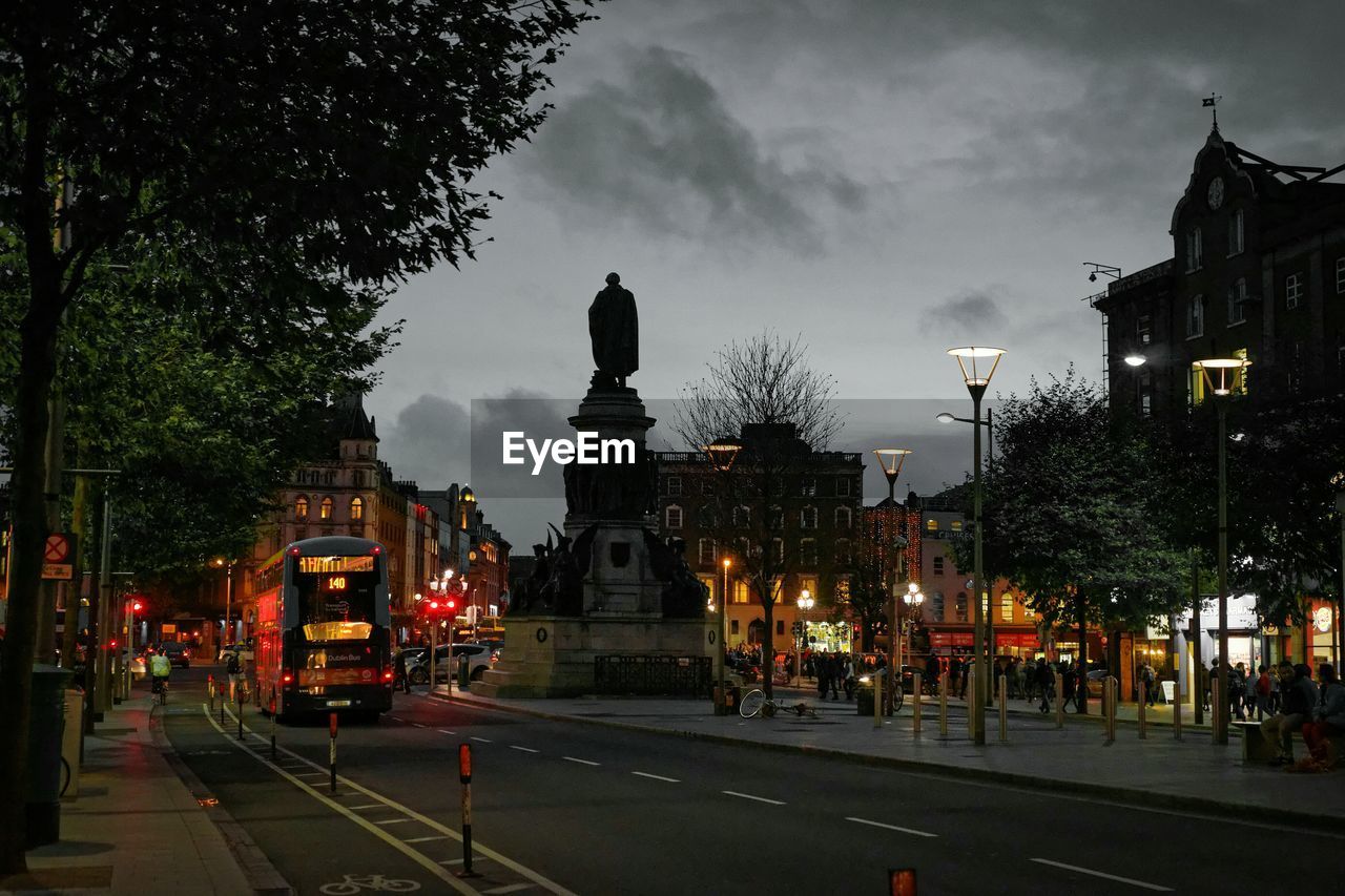 Statue in city against sky