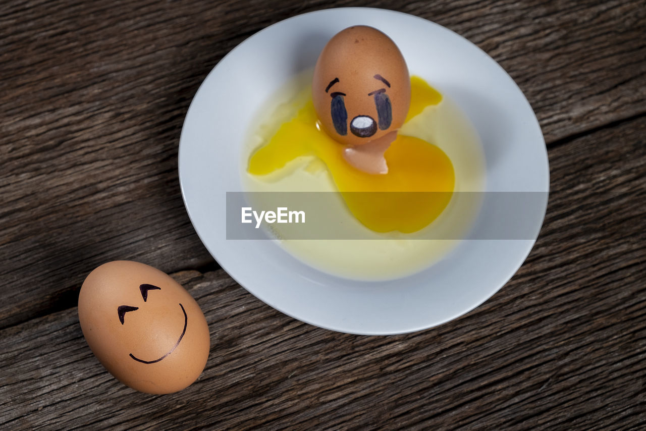 High angle view of broken emoji egg on table