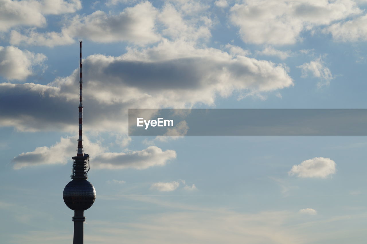 LOW ANGLE VIEW OF COMMUNICATIONS TOWER IN CLOUDY SKY