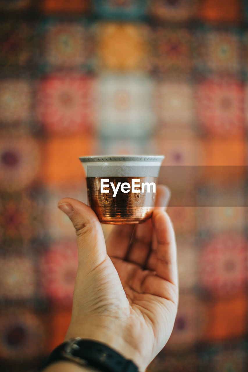 Close-up of hand holding coffee cup