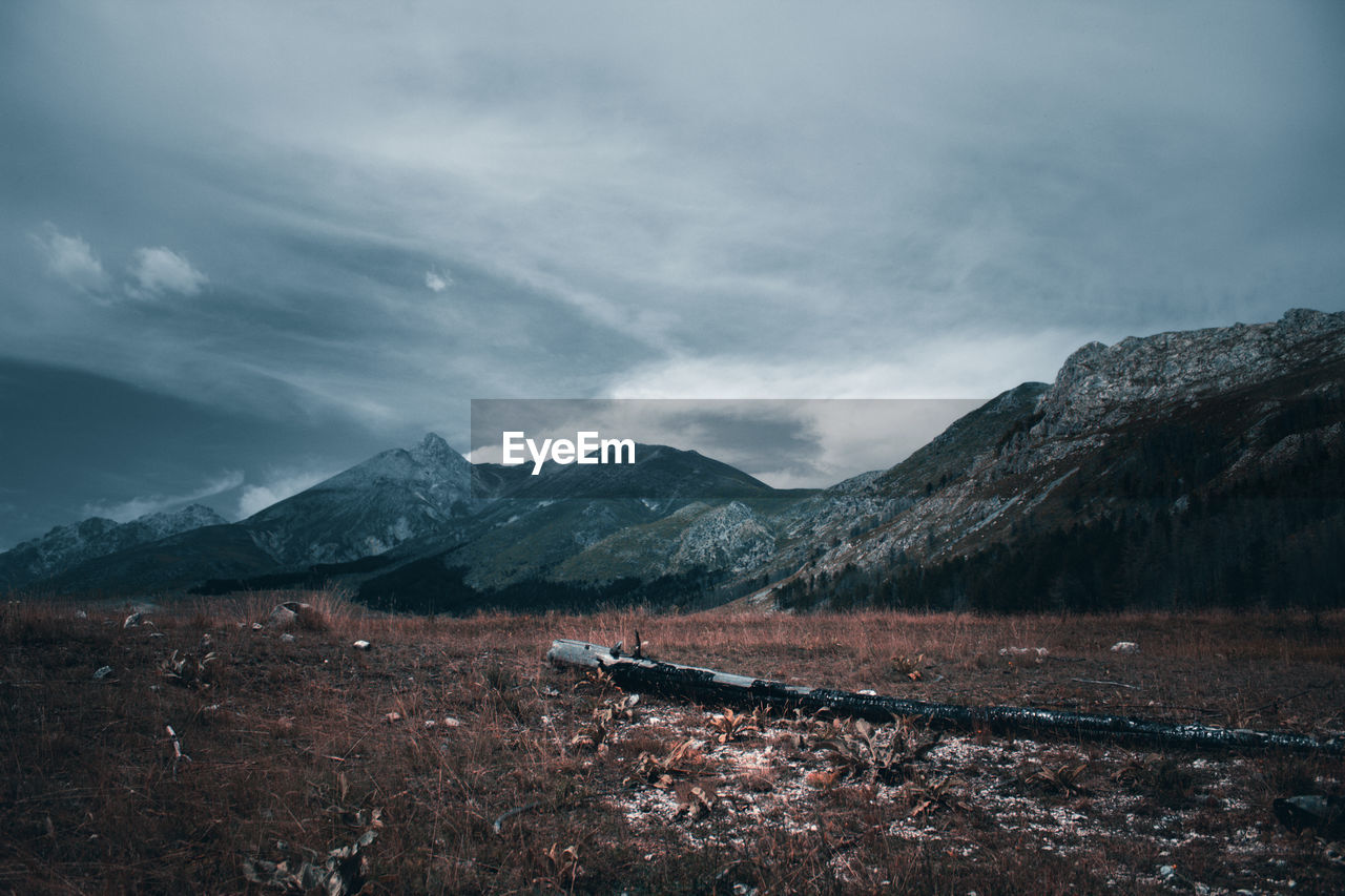 Scenic view of land and mountains against sky